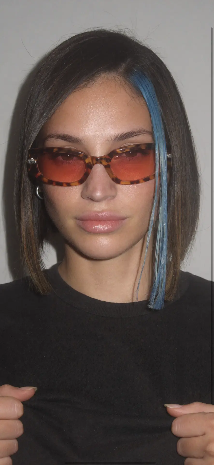 STORMZIIIS wearing tinted sunglasses with a blue streak in their hair